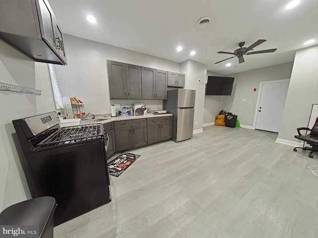 kitchen featuring stainless steel fridge, washer / dryer, ceiling fan, and light hardwood / wood-style flooring