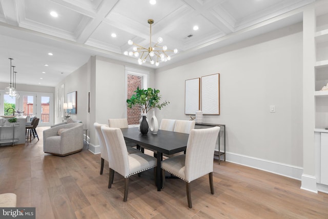 dining area featuring beamed ceiling, an inviting chandelier, and light hardwood / wood-style floors