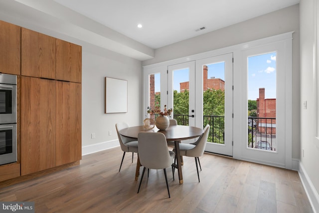 dining area with french doors and light hardwood / wood-style flooring