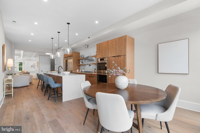 dining area with sink and light hardwood / wood-style floors