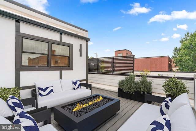 wooden deck featuring an outdoor living space with a fire pit