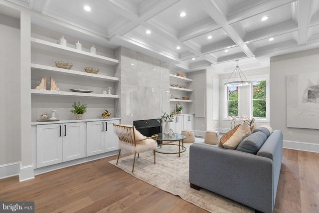 living room featuring coffered ceiling, beam ceiling, built in features, and light hardwood / wood-style floors