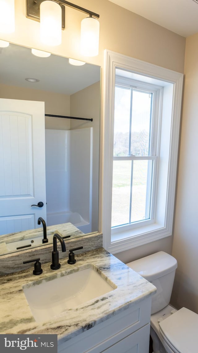 full bath with a shower, vanity, and toilet