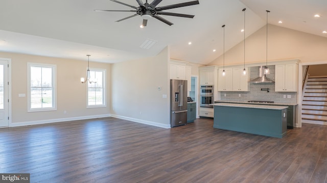 kitchen featuring stainless steel appliances, white cabinets, hanging light fixtures, light countertops, and wall chimney exhaust hood