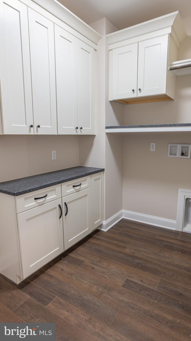 laundry room featuring cabinet space, hookup for a washing machine, baseboards, and dark wood-type flooring