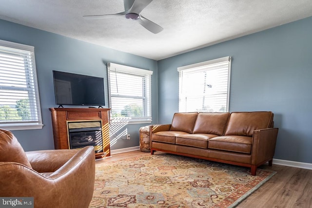 living room with plenty of natural light, ceiling fan, a textured ceiling, and hardwood / wood-style flooring