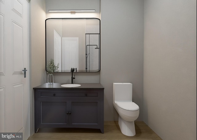 bathroom featuring vanity, hardwood / wood-style flooring, and toilet