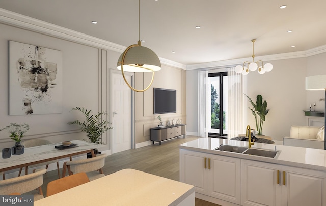 kitchen featuring sink, white cabinetry, light hardwood / wood-style flooring, ornamental molding, and pendant lighting