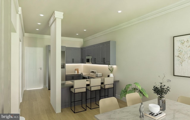 dining area with ornamental molding, decorative columns, and light wood-type flooring