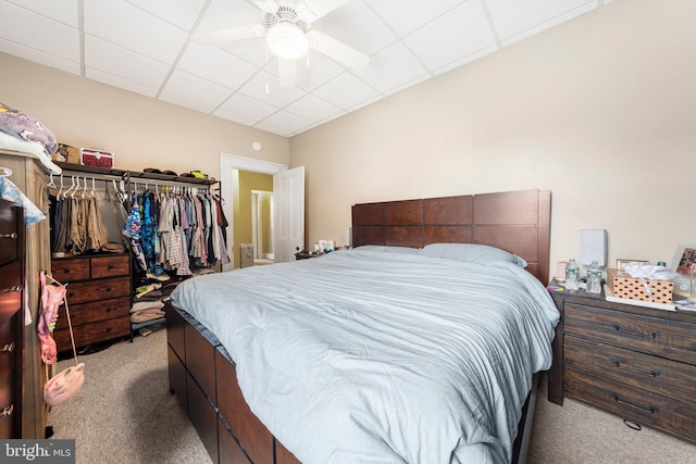 carpeted bedroom featuring a paneled ceiling and ceiling fan