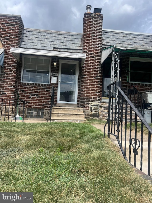 entrance to property featuring a lawn