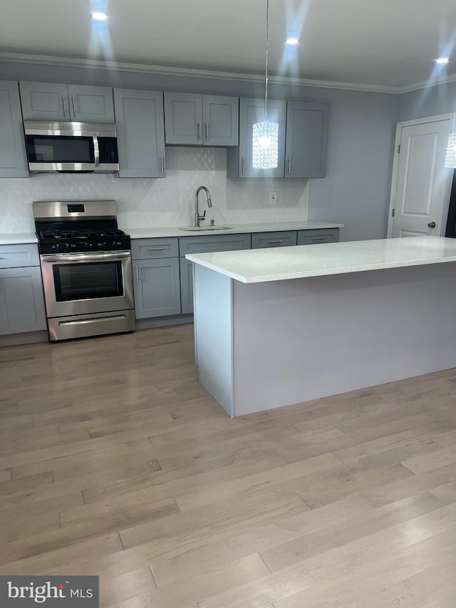 kitchen featuring stainless steel appliances, light hardwood / wood-style flooring, sink, and gray cabinetry