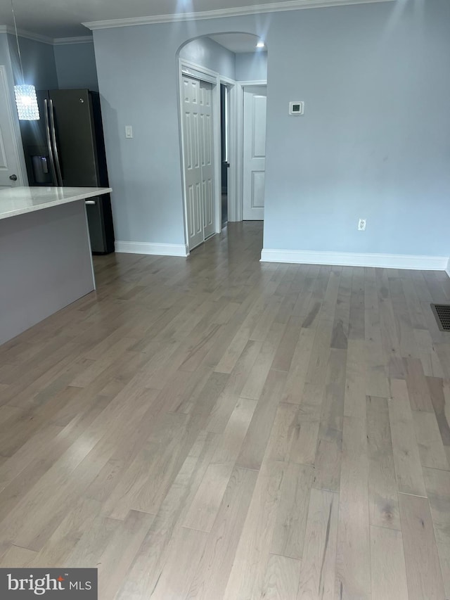 spare room with crown molding and light hardwood / wood-style floors