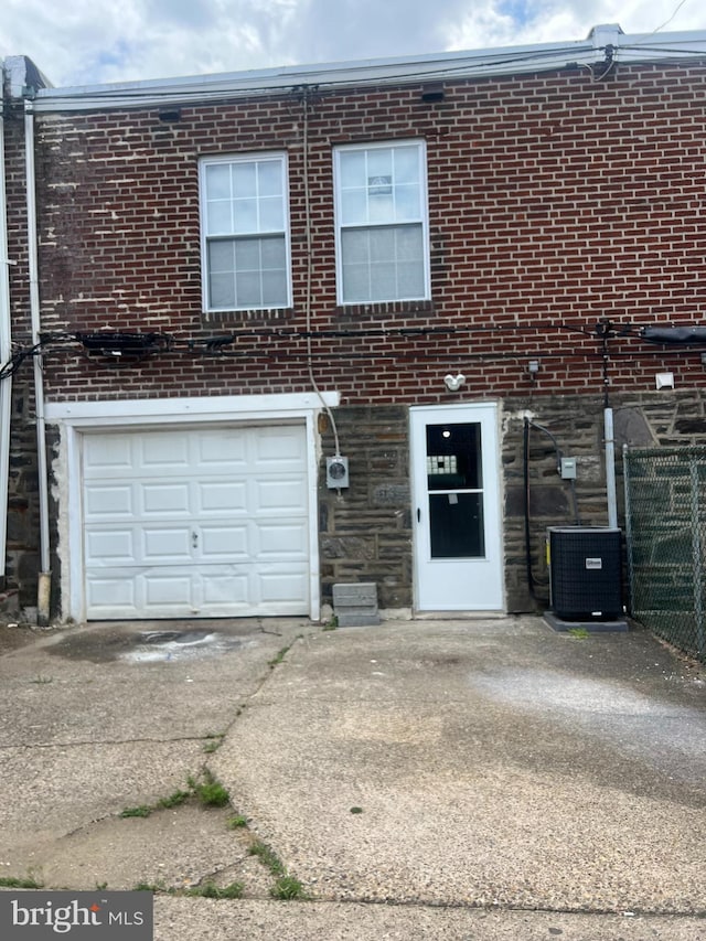 view of front of home featuring a garage and cooling unit