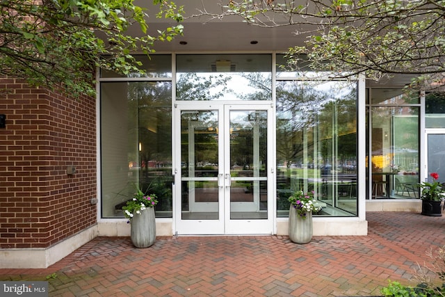 property entrance featuring brick siding and french doors