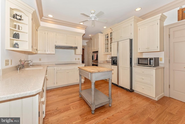 kitchen featuring light wood-type flooring, black electric stovetop, sink, and paneled built in refrigerator