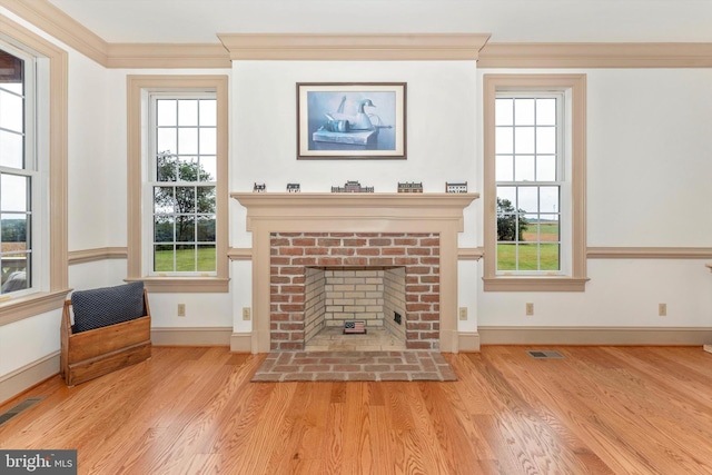 unfurnished living room featuring crown molding, a fireplace, and light hardwood / wood-style floors