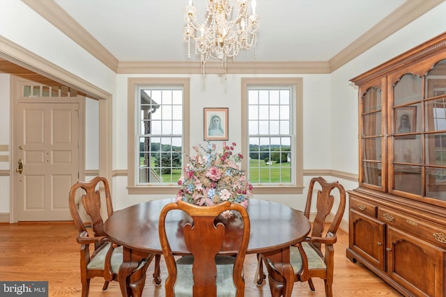 dining space with crown molding, a wealth of natural light, and light hardwood / wood-style floors