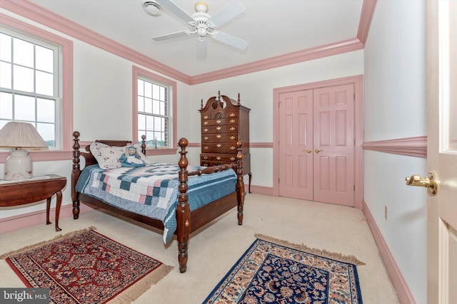 carpeted bedroom featuring crown molding and ceiling fan