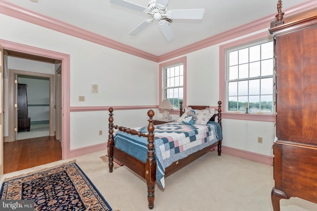 bedroom with crown molding, light colored carpet, and ceiling fan