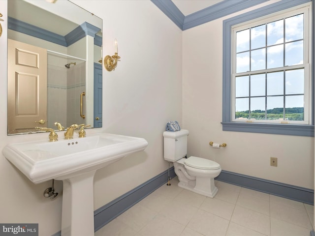 bathroom with sink, ornamental molding, tiled shower, toilet, and tile patterned floors