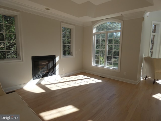 unfurnished living room featuring hardwood / wood-style flooring and ornamental molding