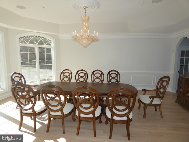 dining area featuring an inviting chandelier, crown molding, and light hardwood / wood-style floors