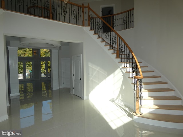 staircase featuring a towering ceiling