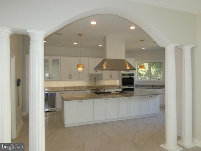 kitchen featuring wine cooler, hanging light fixtures, white cabinets, and island exhaust hood