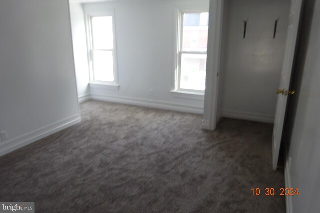 carpeted empty room featuring plenty of natural light