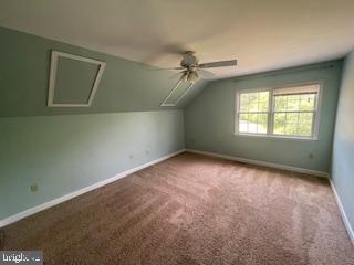 additional living space featuring carpet, ceiling fan, and vaulted ceiling