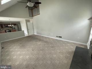 unfurnished living room with carpet, ceiling fan, and vaulted ceiling