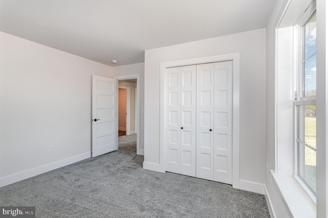 unfurnished bedroom featuring a closet and light carpet