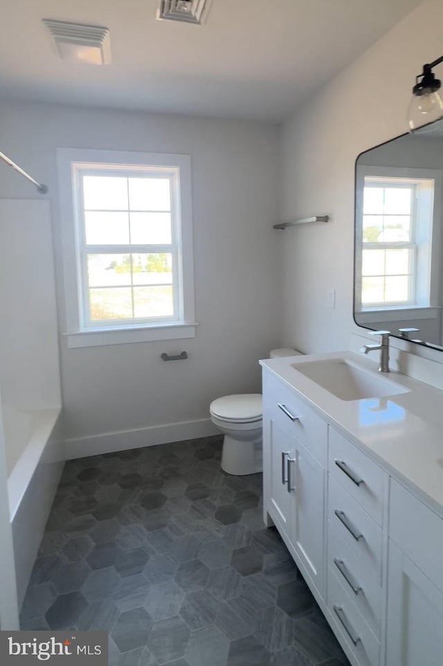 full bathroom featuring vanity, shower / bathing tub combination, toilet, and plenty of natural light