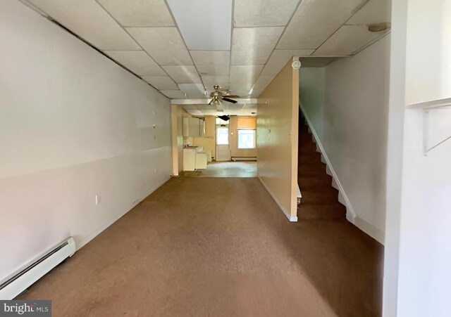 corridor with a drop ceiling, baseboard heating, and carpet flooring