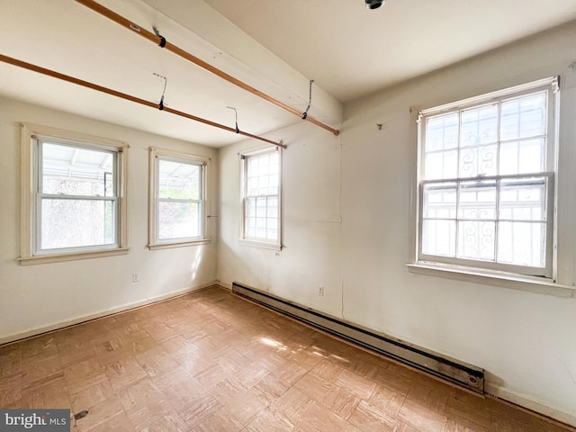 spare room featuring light parquet flooring and a baseboard heating unit