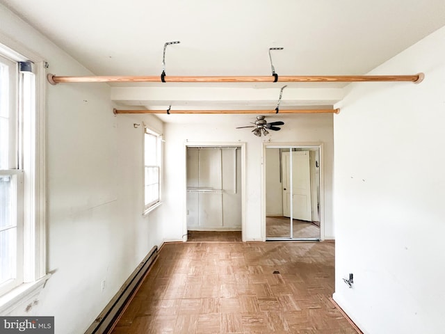 empty room with baseboard heating, parquet floors, and ceiling fan