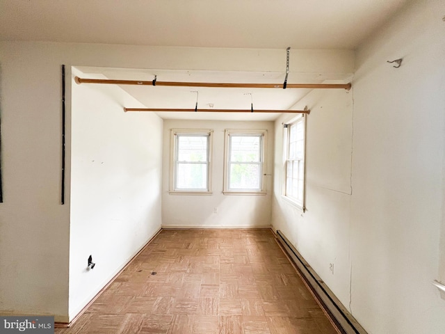 spare room with a baseboard heating unit and light parquet floors