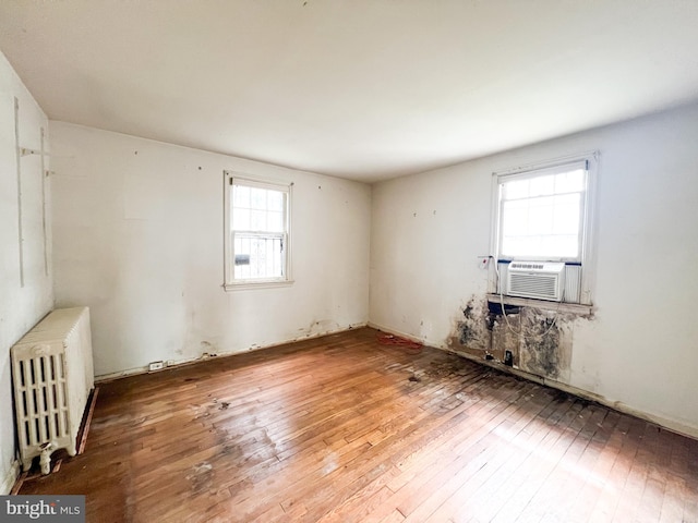 spare room featuring wood-type flooring and radiator