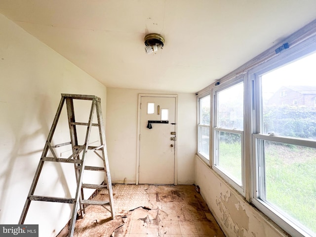 unfurnished sunroom featuring vaulted ceiling