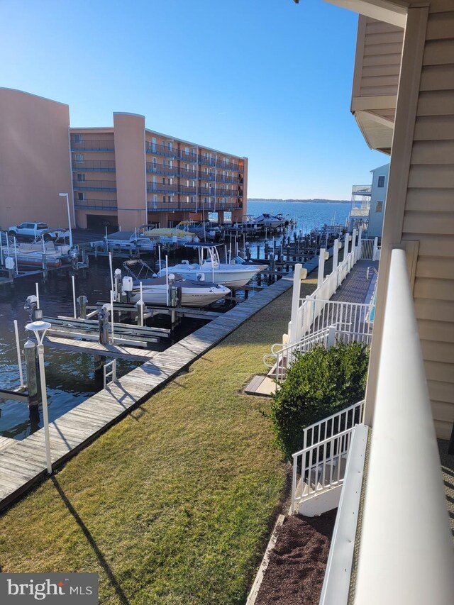 dock area featuring a water view and a lawn