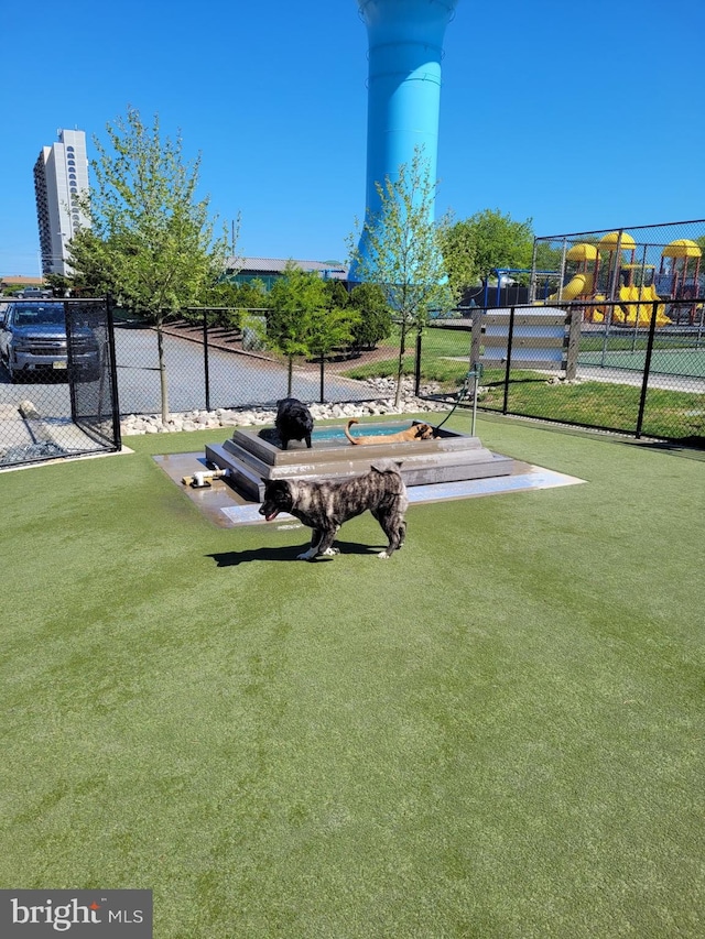 view of home's community with a playground and a lawn