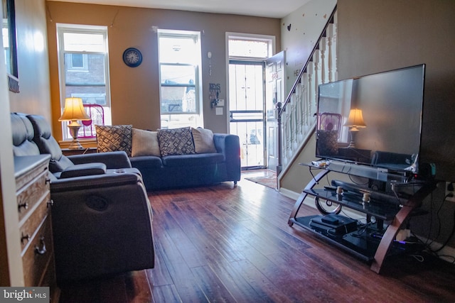 living room featuring dark wood-type flooring and a healthy amount of sunlight