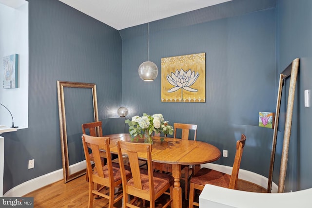 dining room with baseboards and wood finished floors