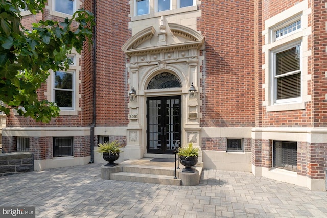 view of exterior entry with french doors and brick siding