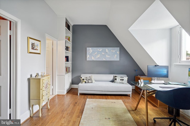 interior space with lofted ceiling, built in shelves, wood finished floors, and baseboards