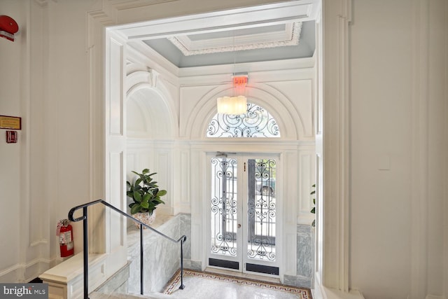 entryway featuring crown molding and french doors