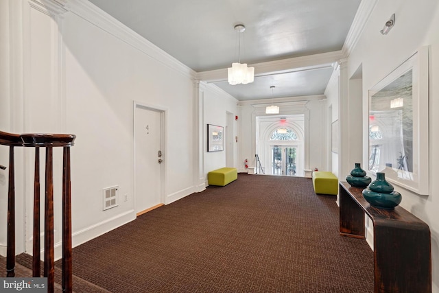 entryway with dark carpet, visible vents, crown molding, and baseboards