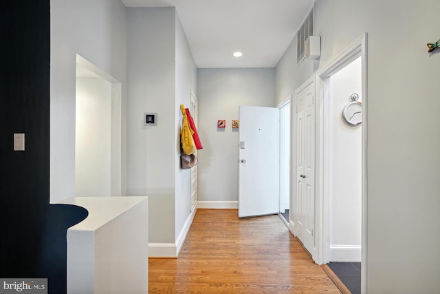 hallway with baseboards, recessed lighting, visible vents, and light wood-style floors