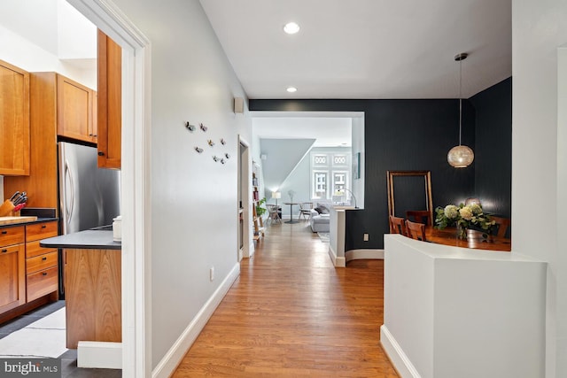 hall featuring light wood-type flooring, baseboards, and recessed lighting